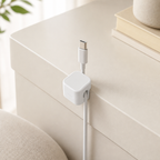 Off-white cable organizer clip holding a cable at a desk edge
