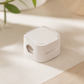 Off-white cable organizer clip on a warm neutral surface