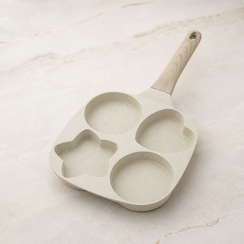 Angled view of cream four-well breakfast pan on an ivory stone counter